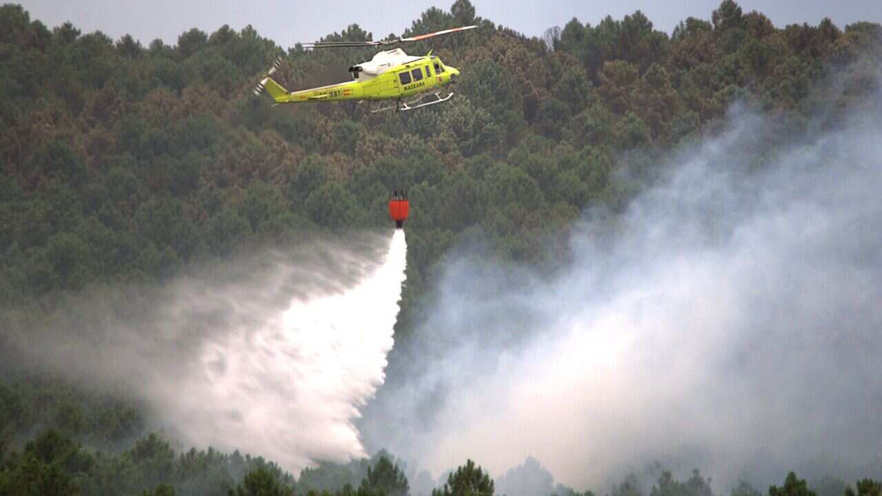 A firefighting helicopter drops water to extinguish a wildfire in Guadalajara, near Veguilla city, on July 19, 2014. (AFP)