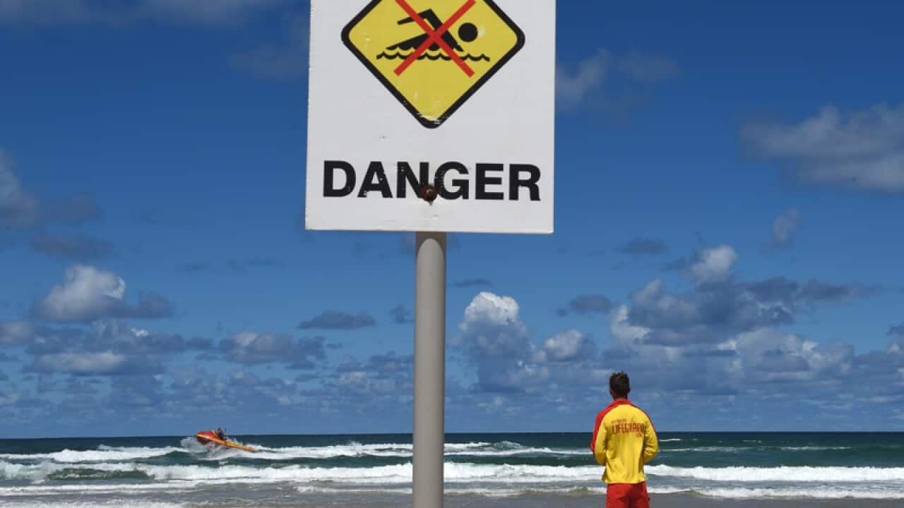 A surf rescue boat searches a beach on the NSW far north coast