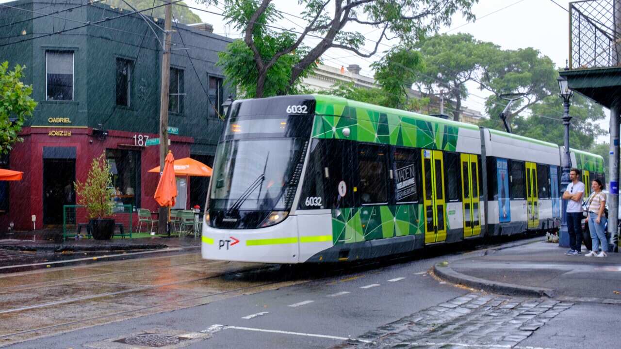 A tram drives through the Fitzroy area during rainfall.