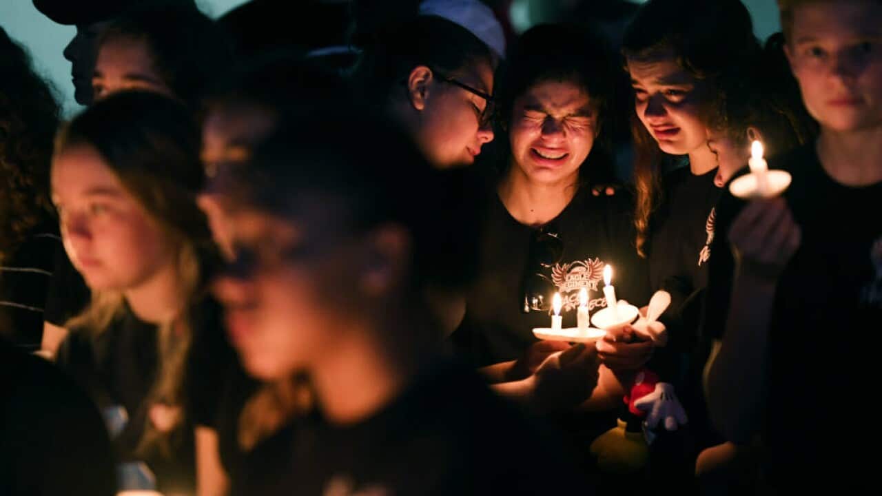 Marianna Guttierez, 14, center, and other students of Marjory Stoneman Douglas High School gather with others for a candlelight vigil in honor of the victims.