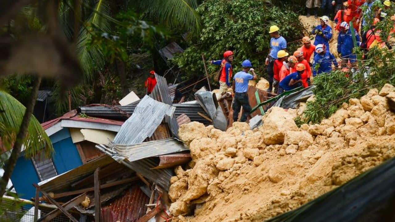  Rescuers search for survivors at the landslide site in Naga City.
