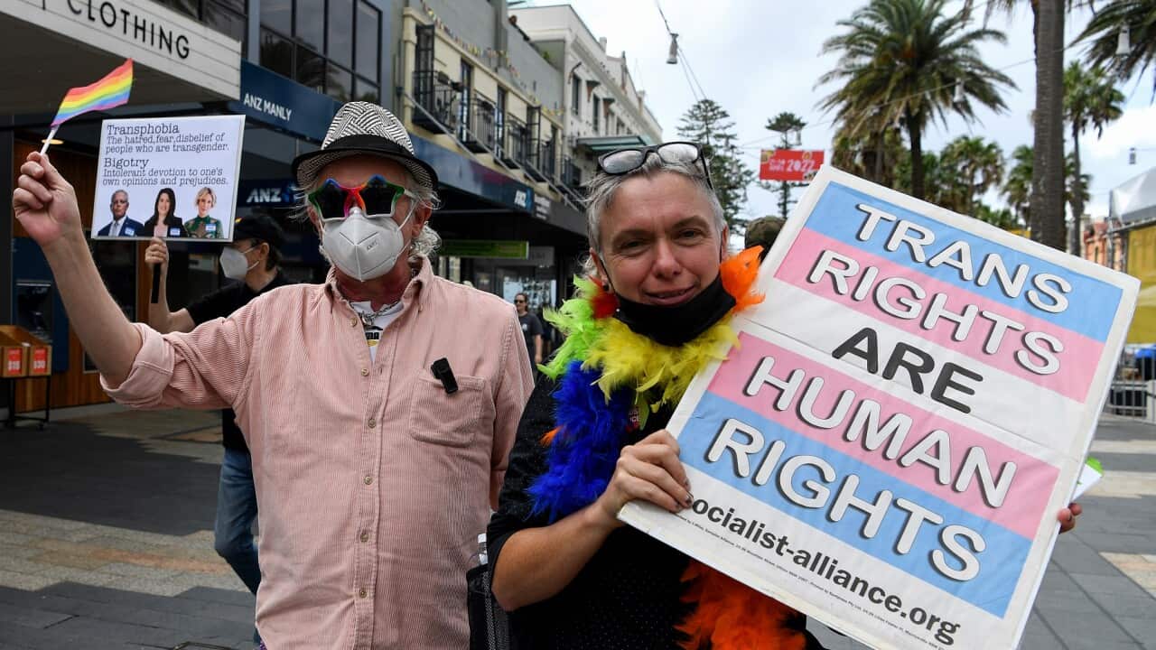 Members of Community Action for Rainbow Rights hold placards as a protest against Liberal candidate Katherine Deves in Manly, Sydney