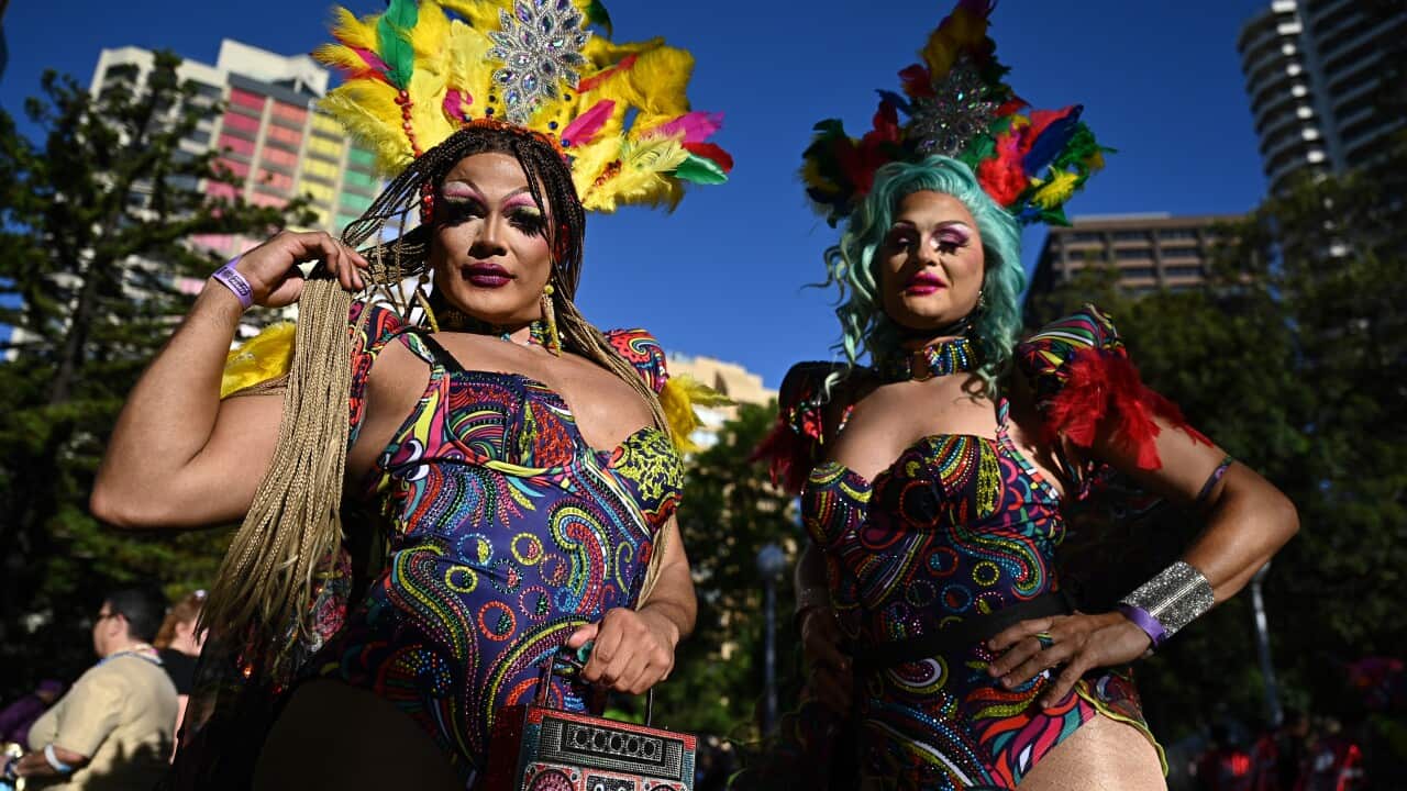 Two people in flamboyant leotards and headdresses