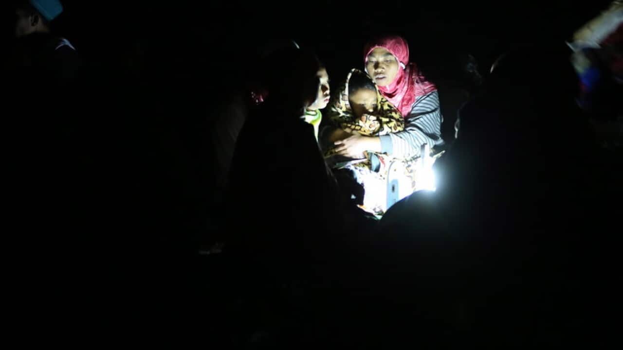 A mother holds her son during aftershocks at Duman Village in Lombok, West Nusa Tenggara, Indonesia