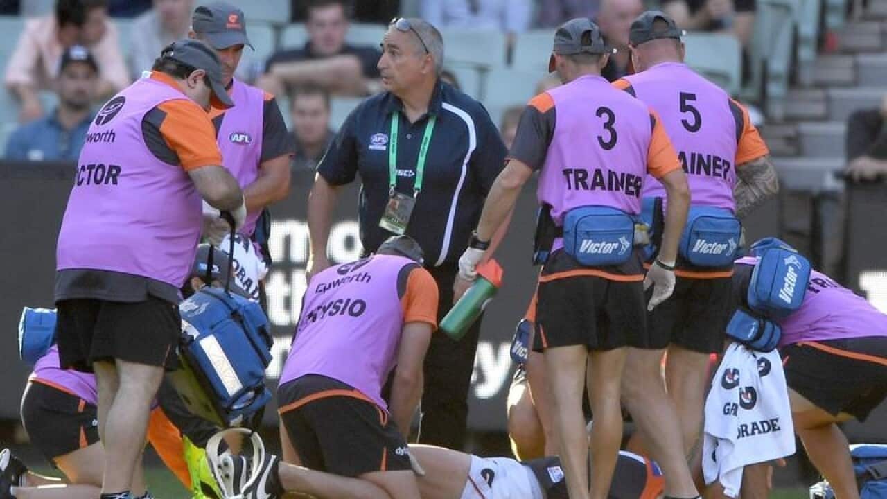 Tom Scully of the Giants is attended to by team medics.