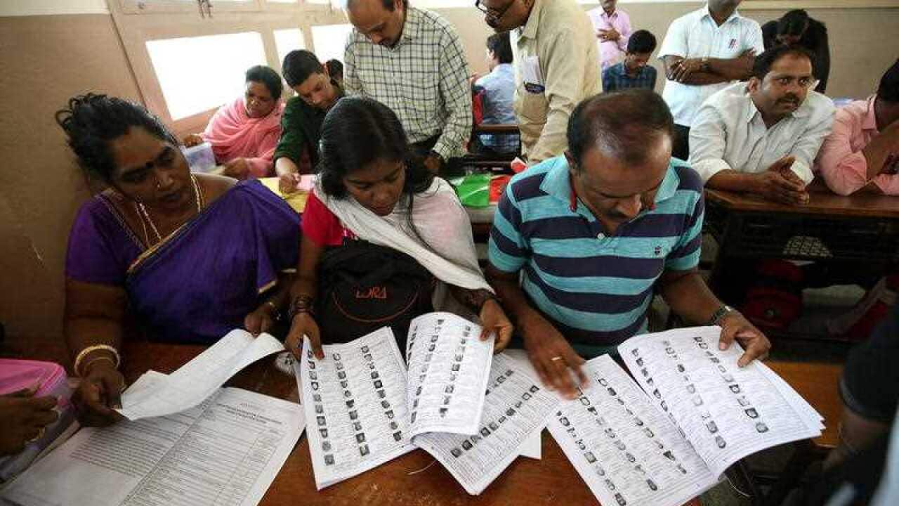 Indian polling staff check the material given by the election officials ahead of the second phase of the parliament election.