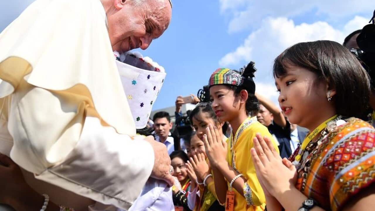 Pope Francis is welcomed by children dressed in traditional clothes
