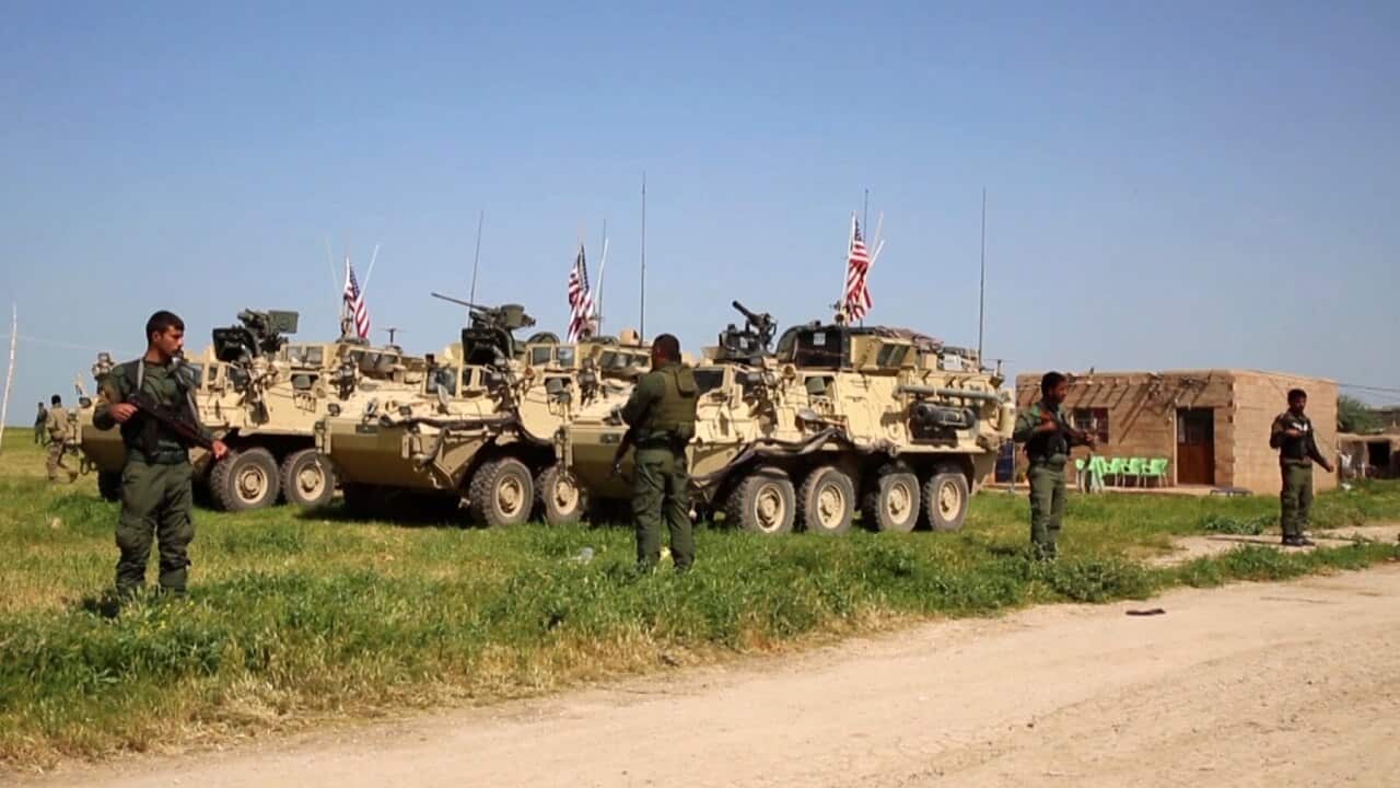Kurdish fighters standing guard as U.S. forces take up position