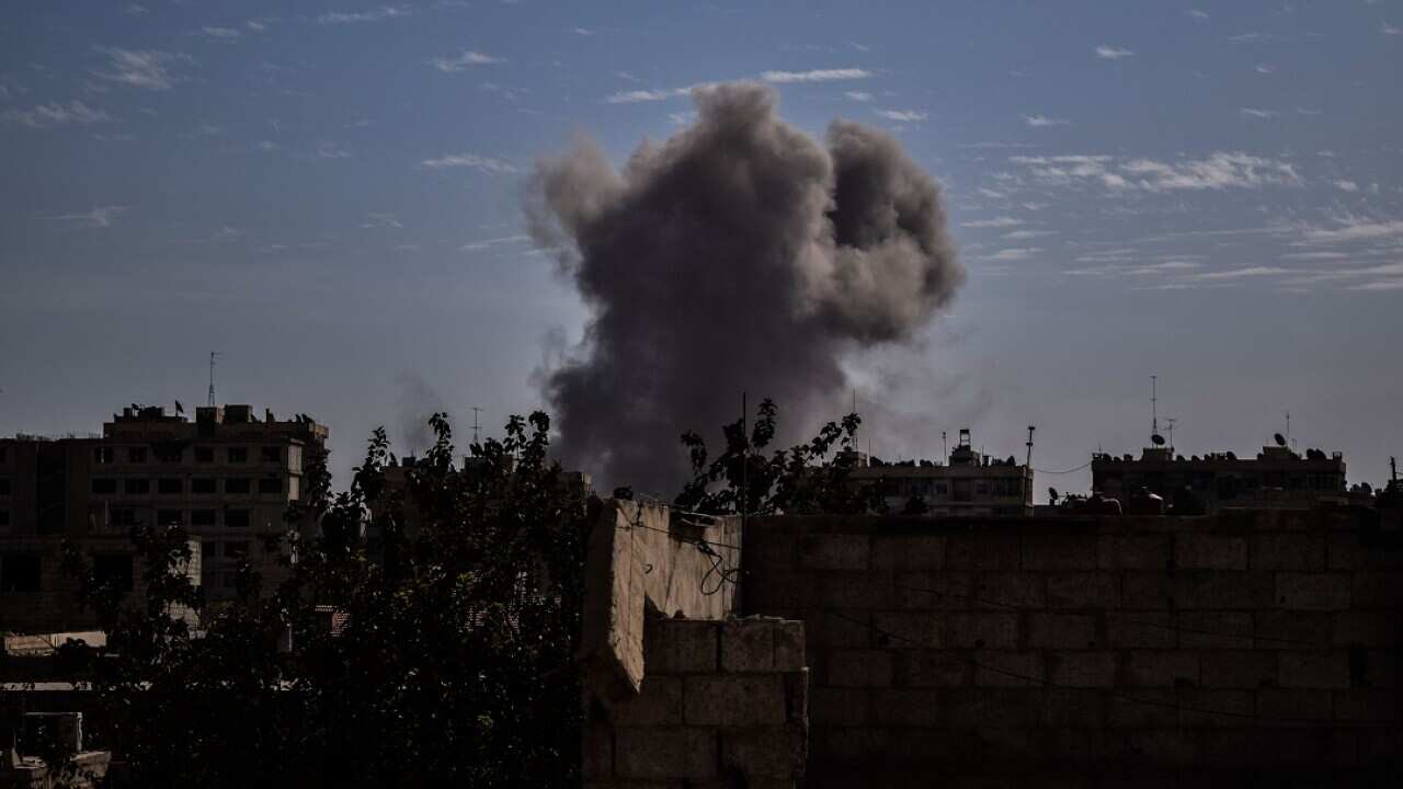 Smoke rises following an air strike on the rebel-held besieged town of Harasta.
