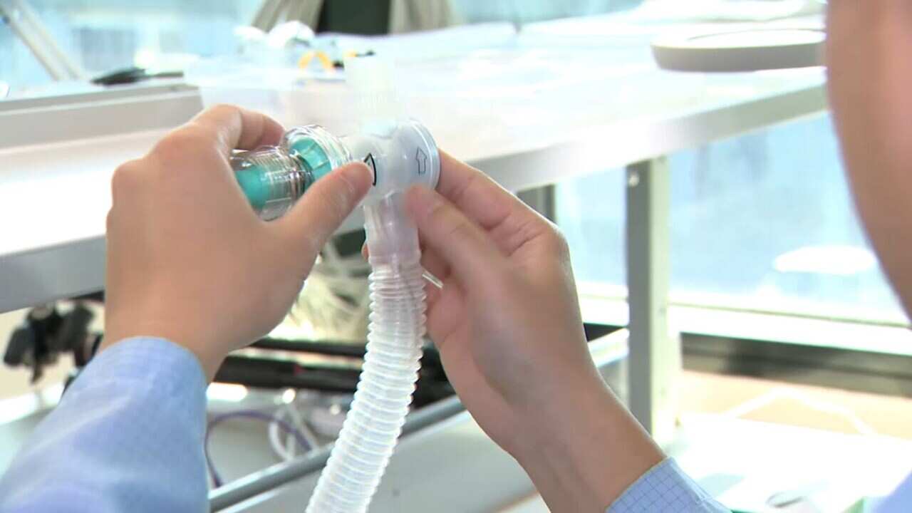 A worker makes a ventilator