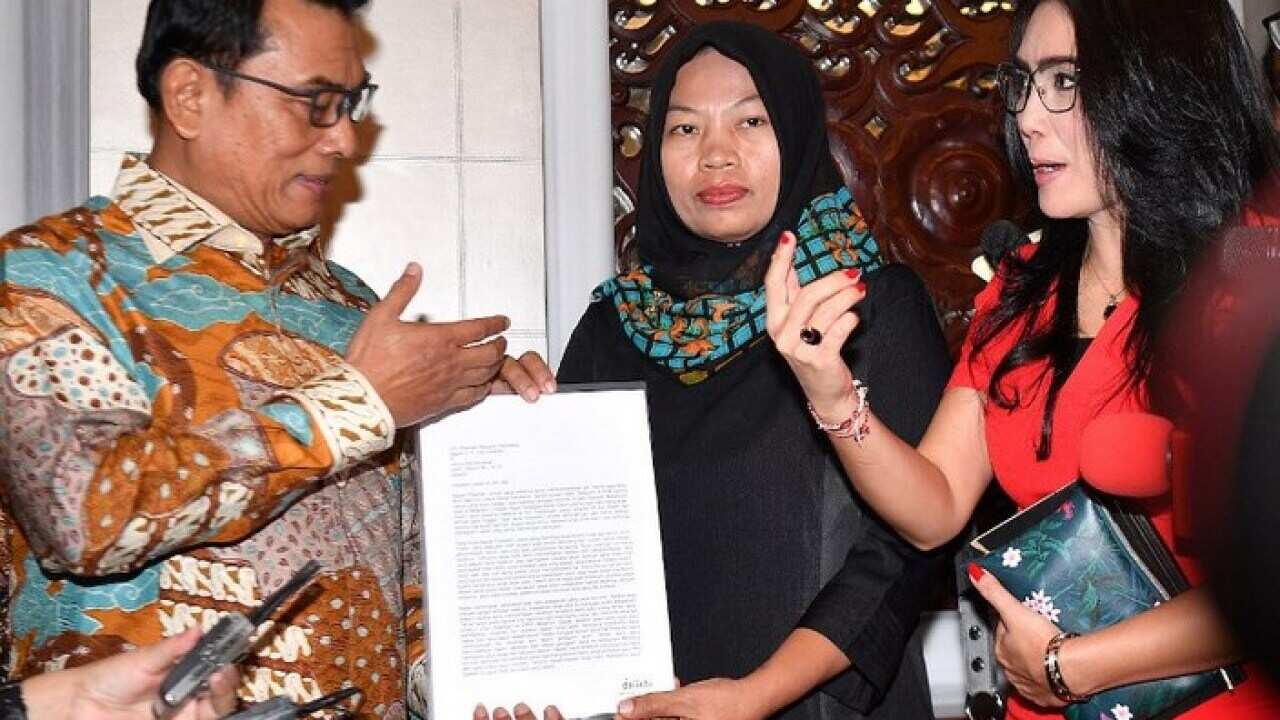 Baiq Nuril Maknun (center) meets with Presidential Chief of Staff Moeldoko to hand over a letter asking for amnesty from President Joko Widodo.