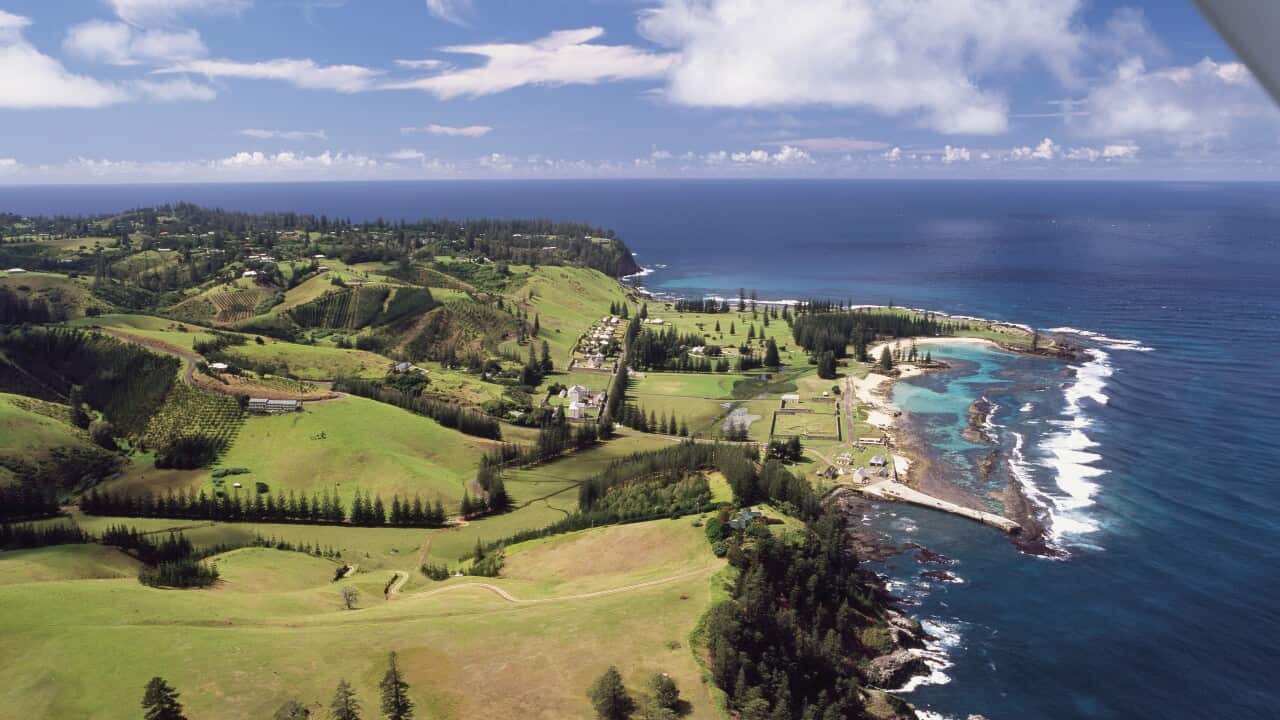 An aerial view of an island encircled by greenery.