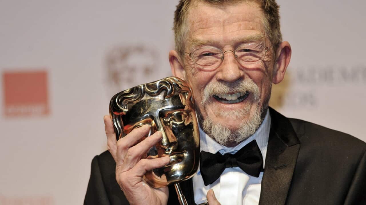 John Hurt posing with his Outstanding British Contribution award