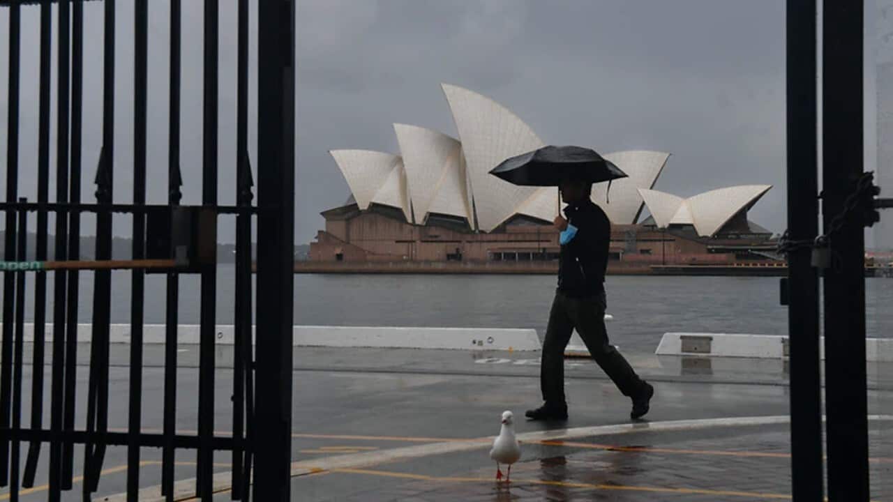 A pedestrian walks past a deserted Sydney Opera House during the city's lockdown.