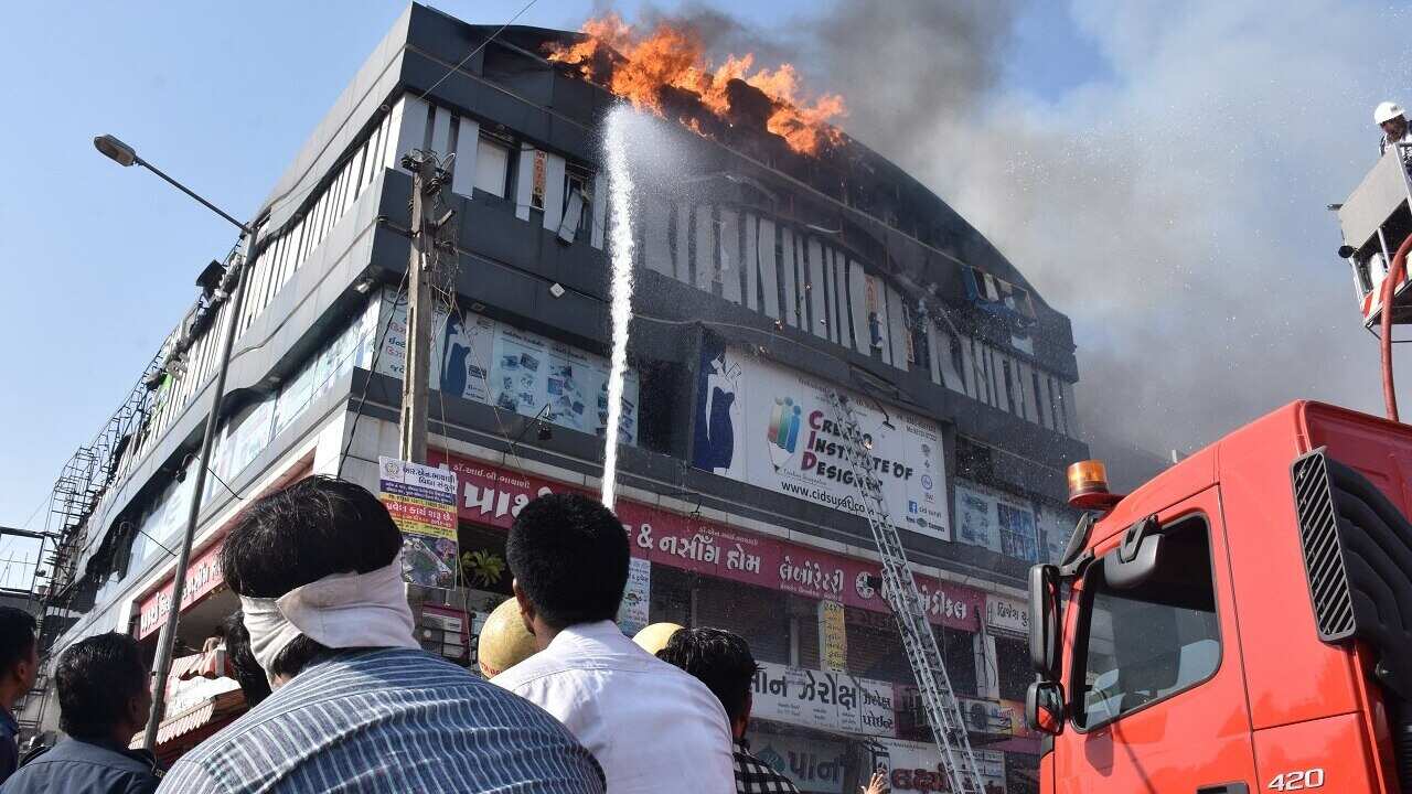 Indian firefighters work to douse fire at a tutoring centre in Surat.