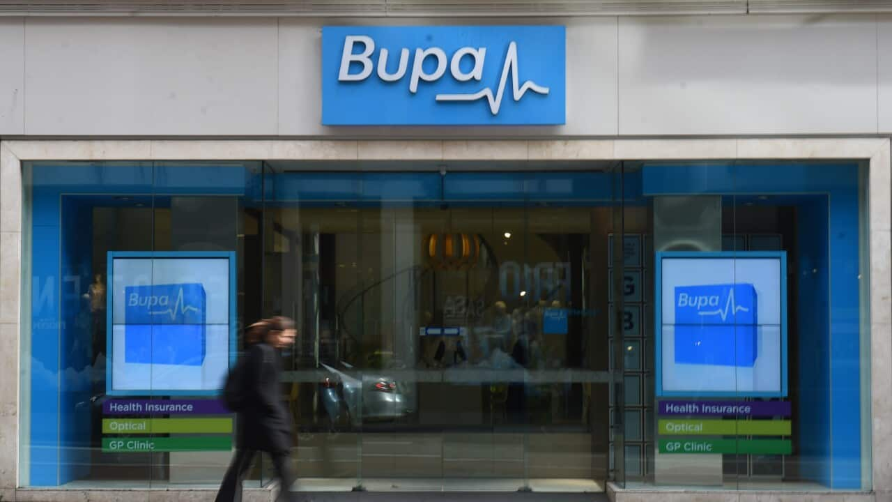 A woman walks past a Bupa Health Insurance branch in Sydney, Monday, July 13, 2015.  (AAP Image/Mick Tsikas) NO ARCHIVING