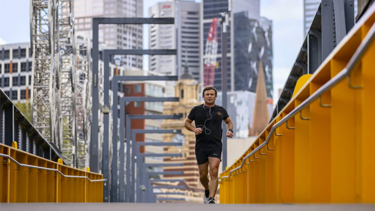 A man is seen exercising along a bridge in Southbank, Melbourne