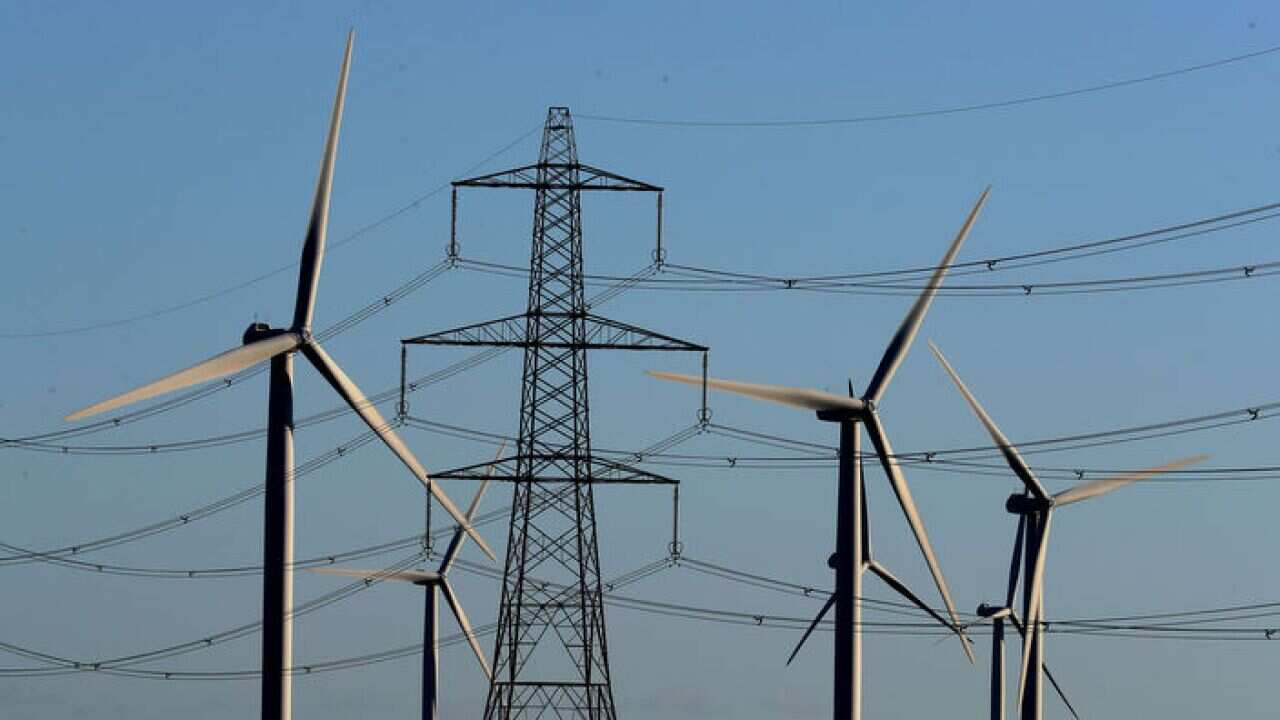A wind farm amongst electricity pylons