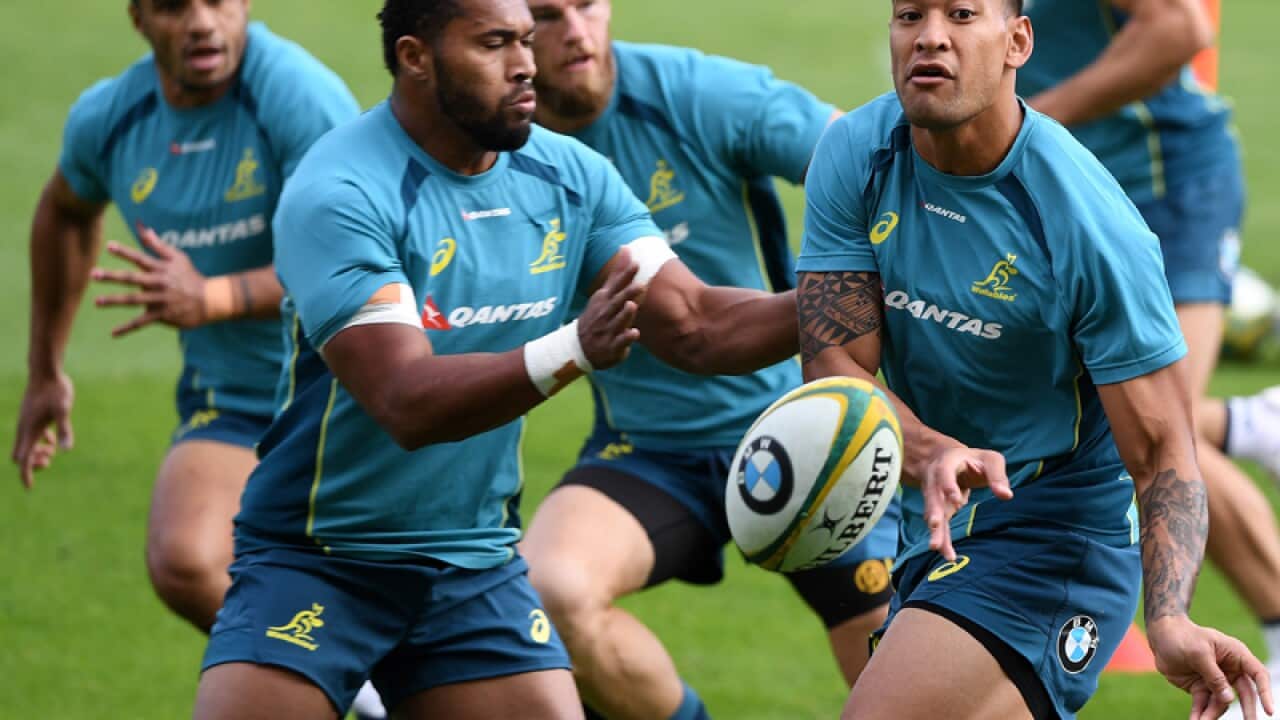 Israel Folau (R) passes the ball during Wallabies training