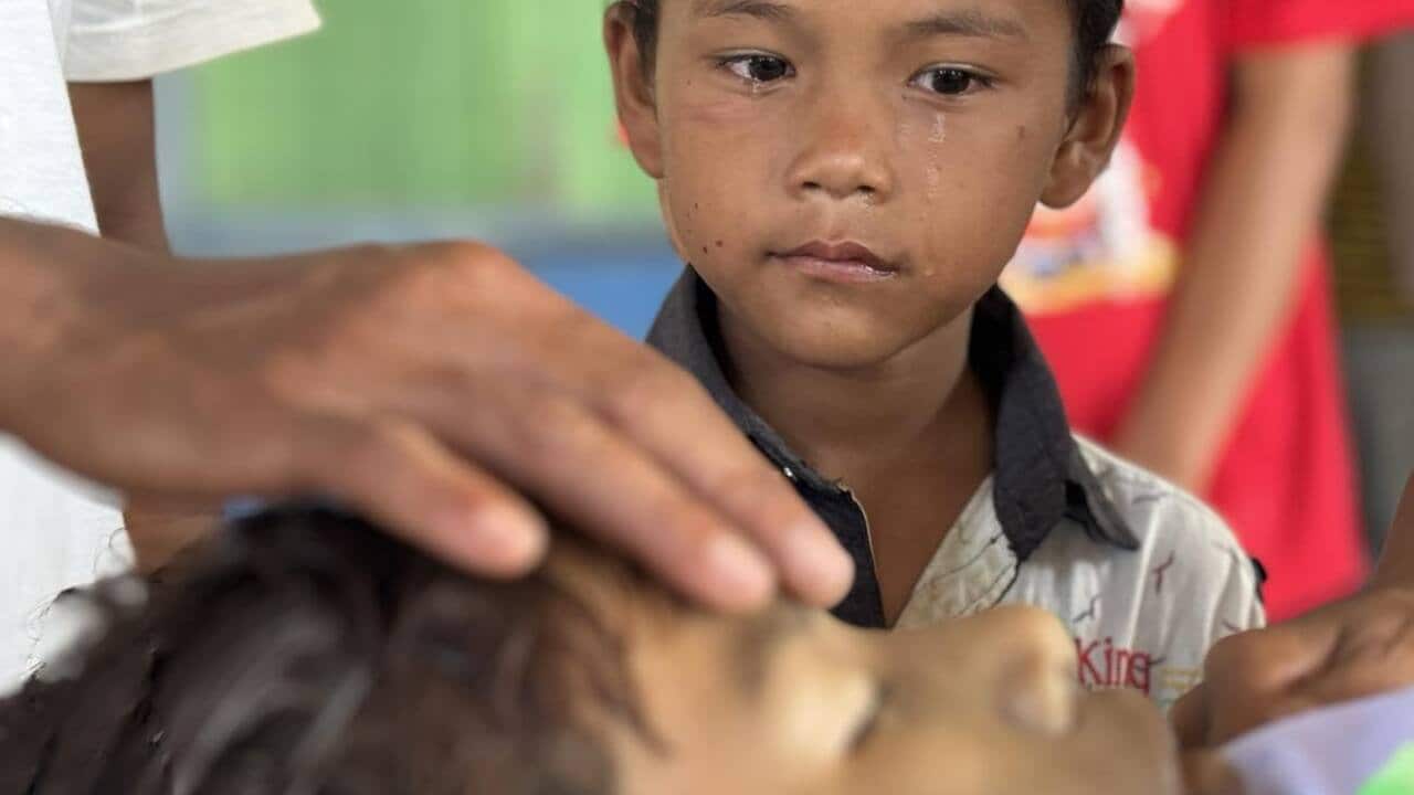 Myanmar boy watching his brother and crying