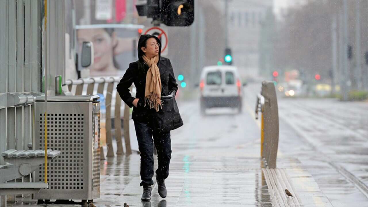 A lone commuter waits for a tram in Melbourne