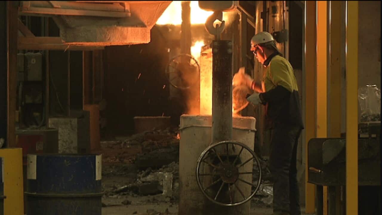 a worker loads scrap into a burner at Intercast and Forge Foundry Karen Ashford SBS.jpg