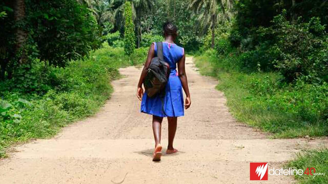 Girls in blue dress walking on dirt road