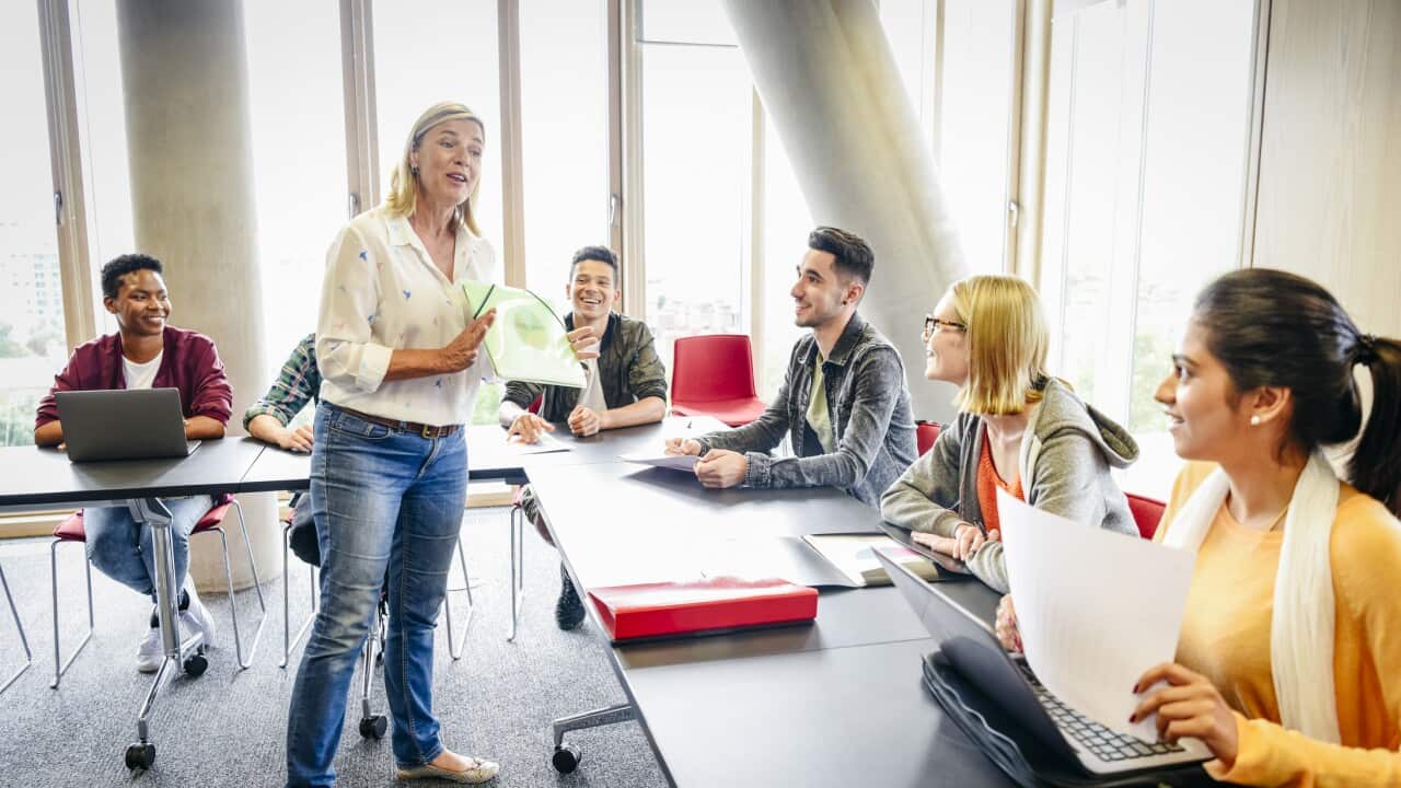 Classroom with mature female teacher and young multi ethnic students