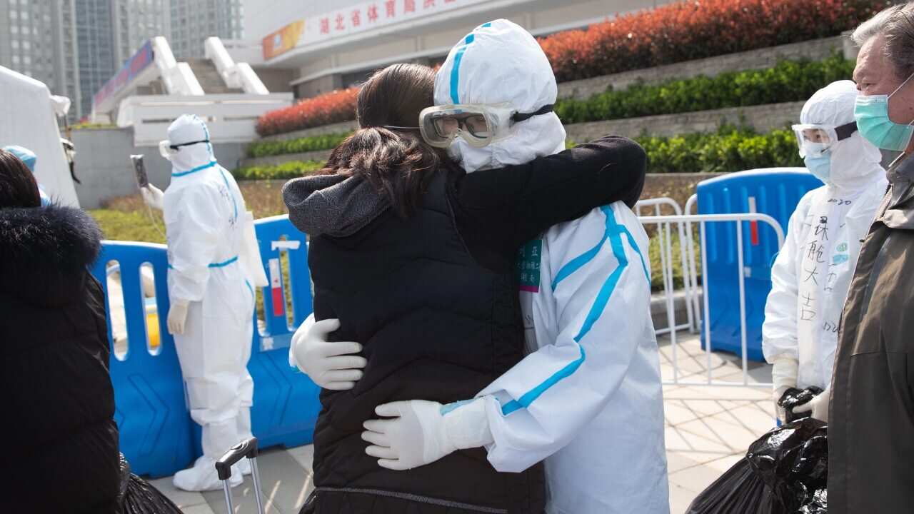 Medical staff and patients hug after patients were discharged at Wuchang Fangcang Hospital, a temporary hospital treating people infected with the coronavirus
