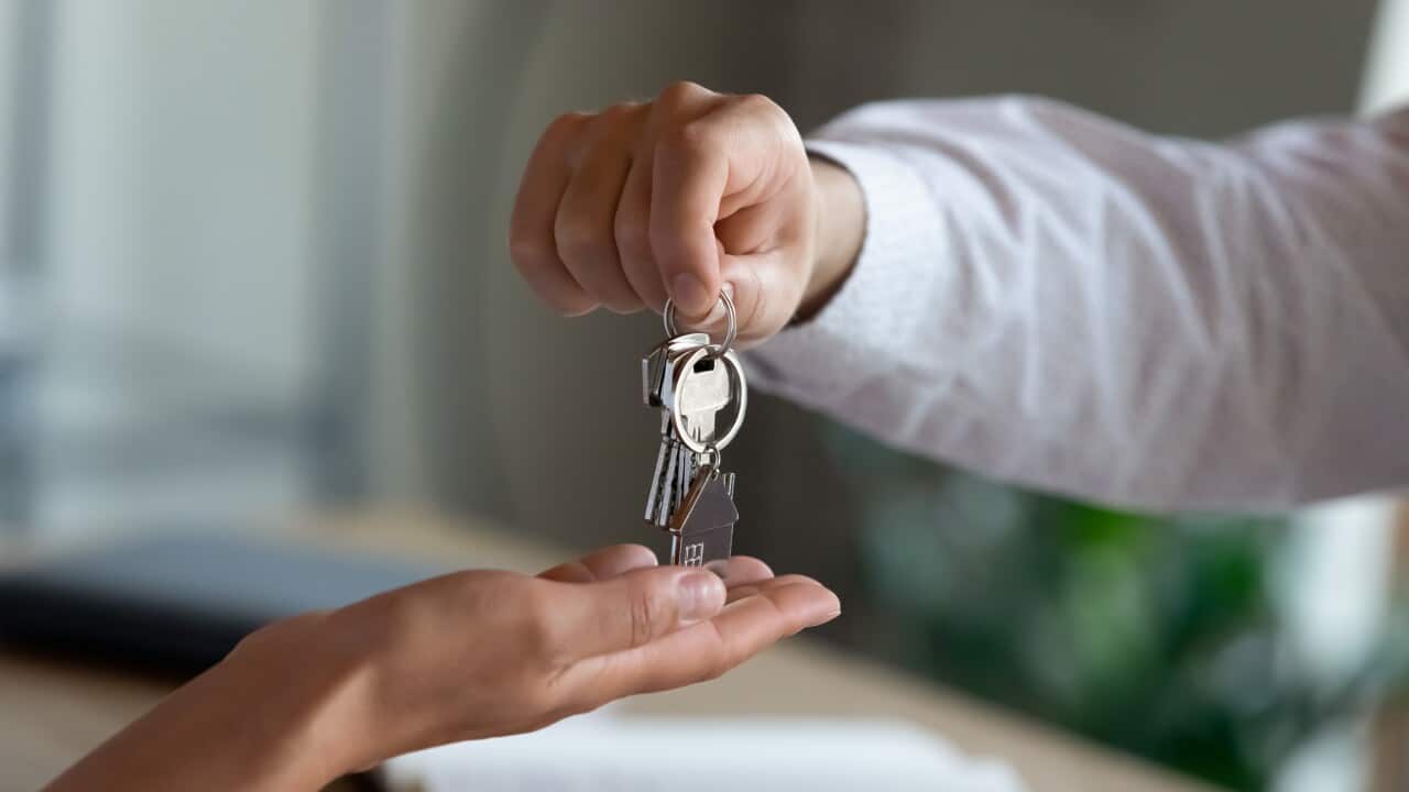 Close up professional Real estate agent giving keys to client.