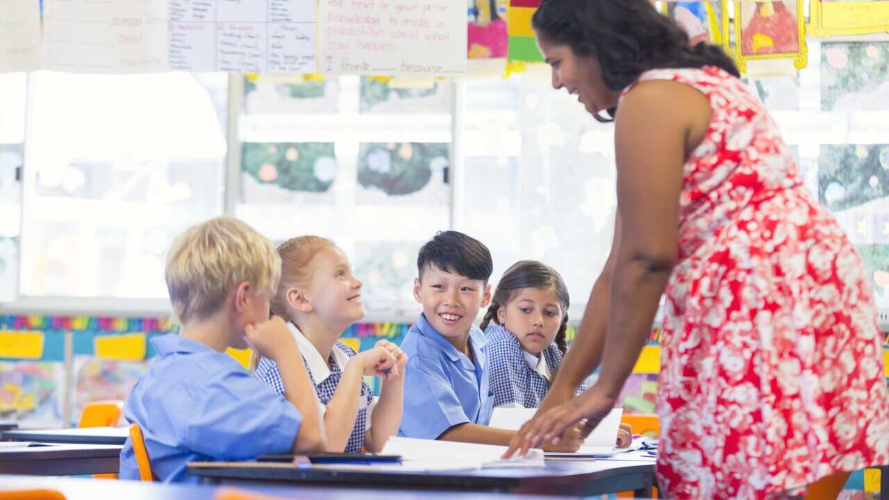 Aboriginal teacher working with children in the classroom.