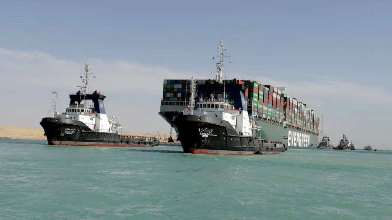 Tugboats near the Ever Given container ship after it was refloated in the Suez Canal