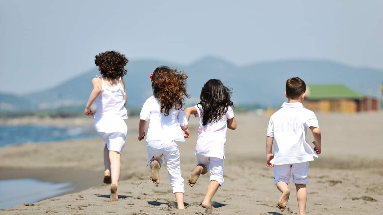 group of happy child on beach who have fun and play games