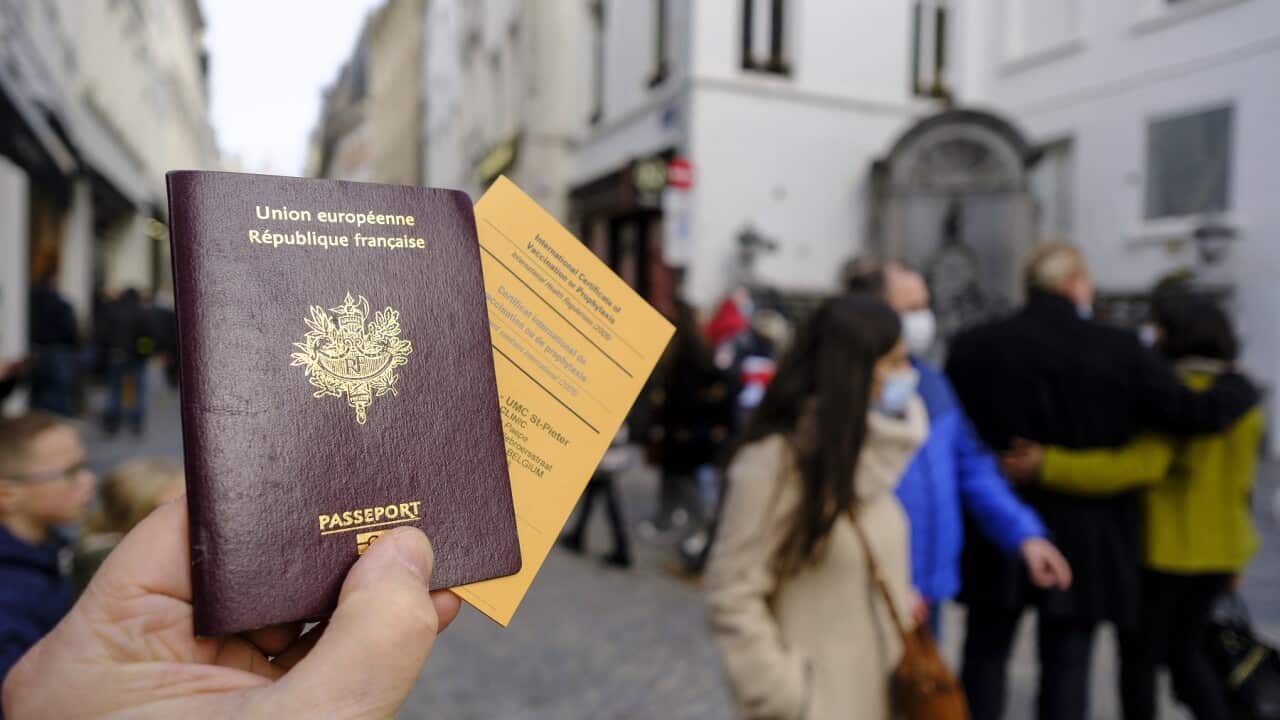 A French passeport and an International Certificate of Vaccination or Prophylaxis are seen in an illstration pictures on February 19, 2021 in Brussels, Belgium. Back is the famous statue of the Manneken-Pis. - Photo by Monasse T/ANDBZ/ABACAPRESS.COM.