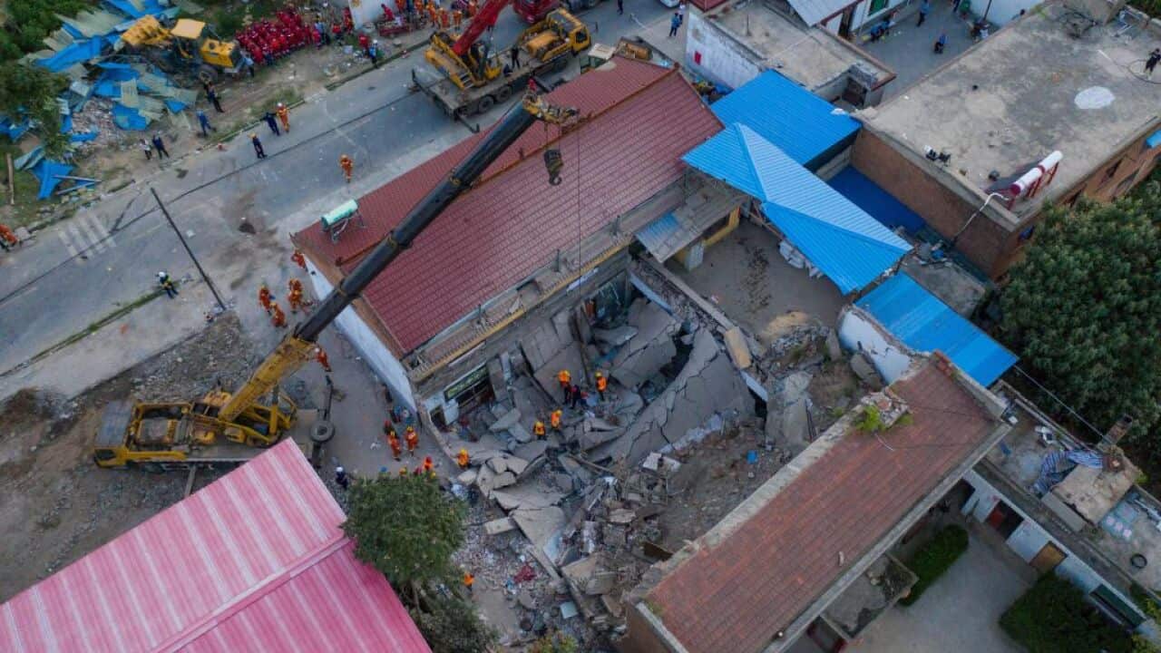 Rescue workers search for survivors in the debris after a two-story building collapsed at Chenzhuang village on August 29, 2020.