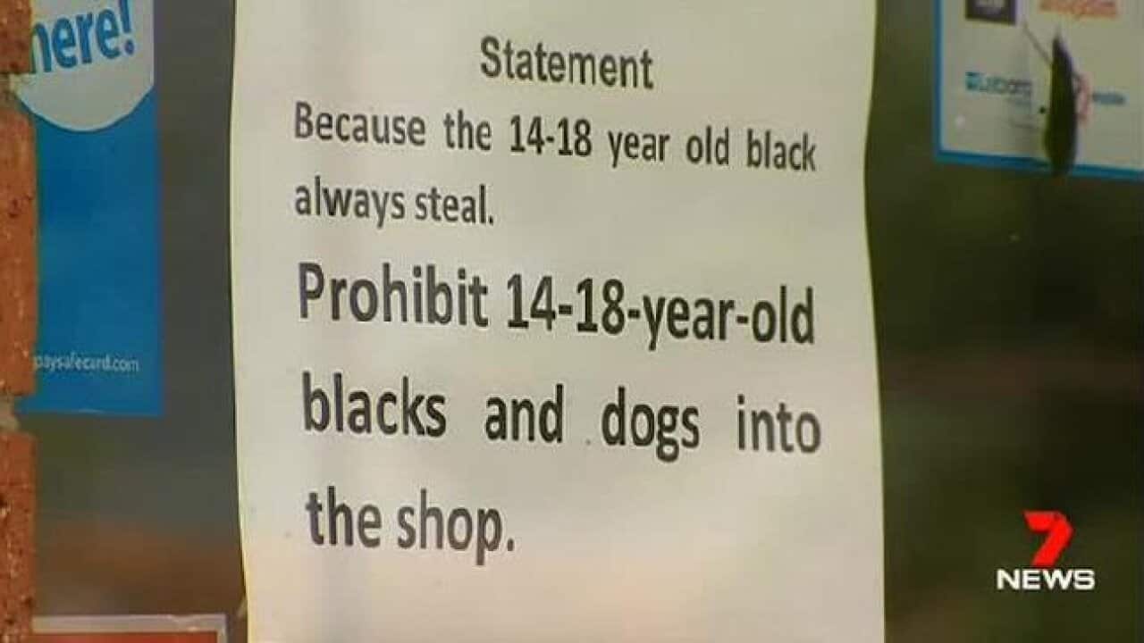 A sign banning black teenagers and dogs from a milk bar in Melton, Melbourne