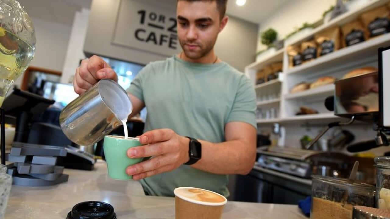 A barista is seen preparing a coffee
