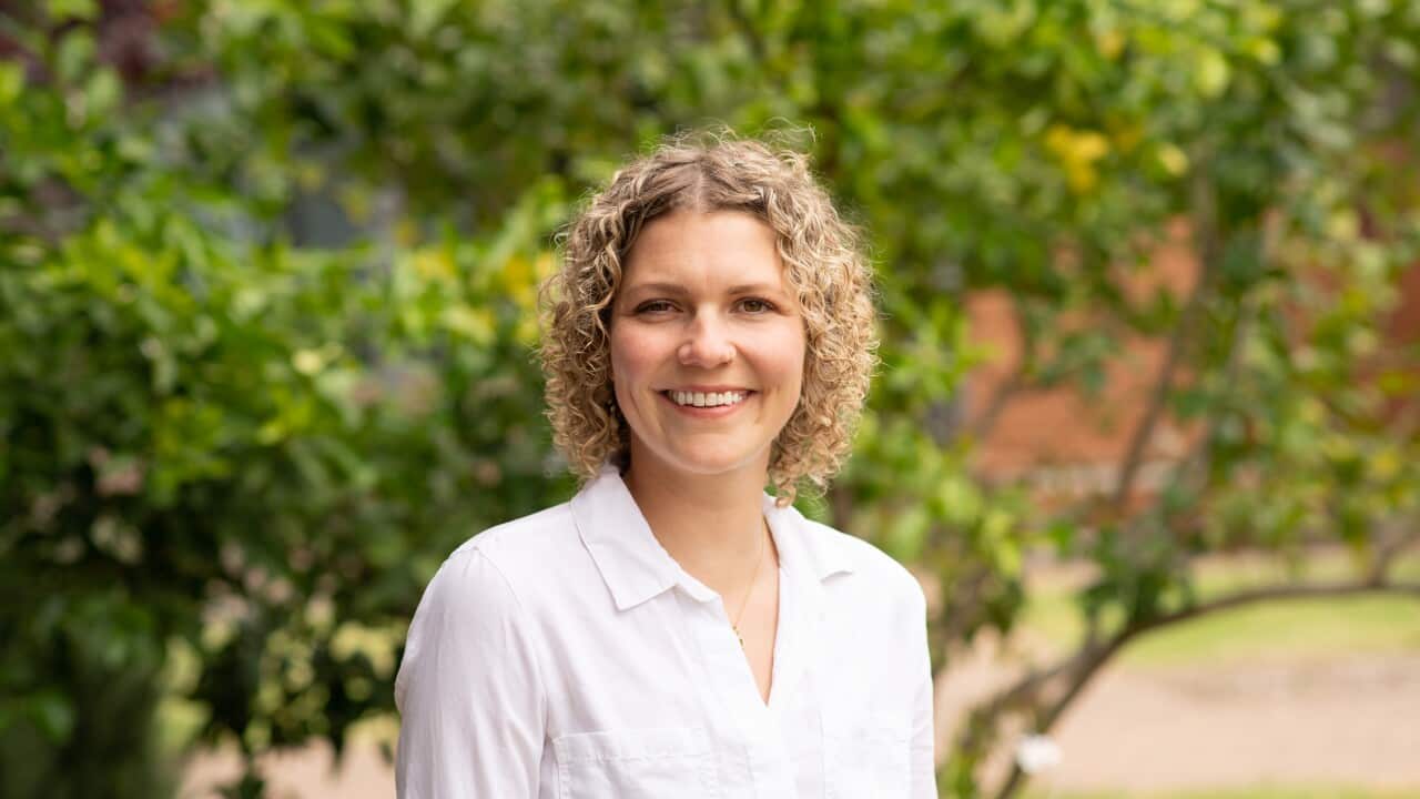A woman in a white shirt smiling
