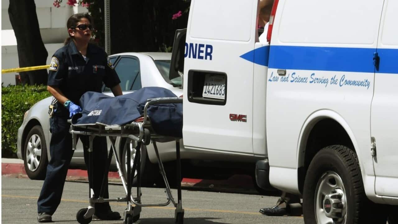 Staff from the Coroners office remove the body of a Chinese national from the front of the Chinese consulate in Los Angeles on Tuesday
