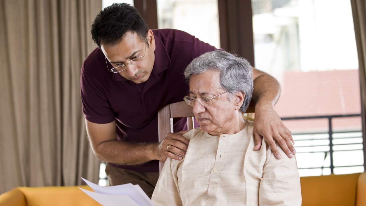 Man with old father reading a document at home