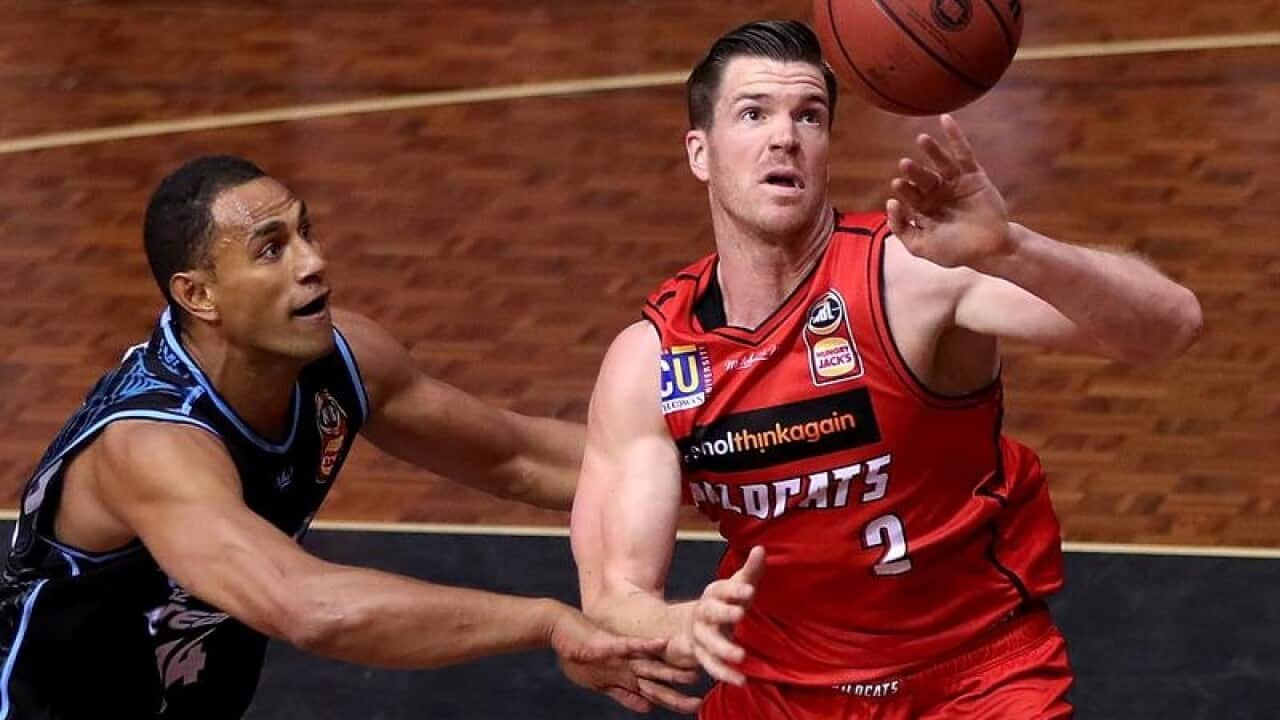 Lucas Walker of the Wildcats challenged by Breakers player.