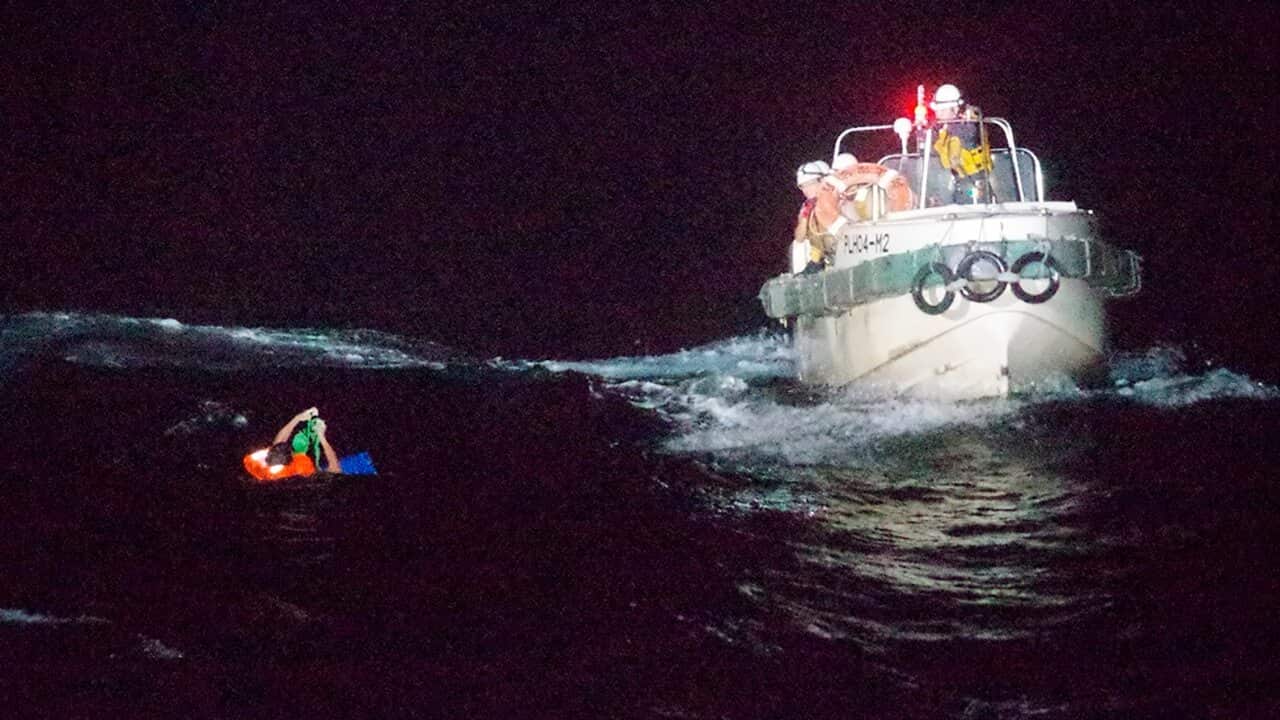 A Filipino crewmember of a Panamanian cargo ship is rescued by Japanese Coast Guard members in the waters off the Amami Oshima