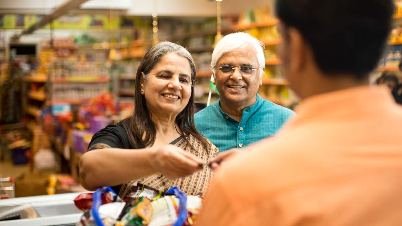 Senior couple paying at store counter