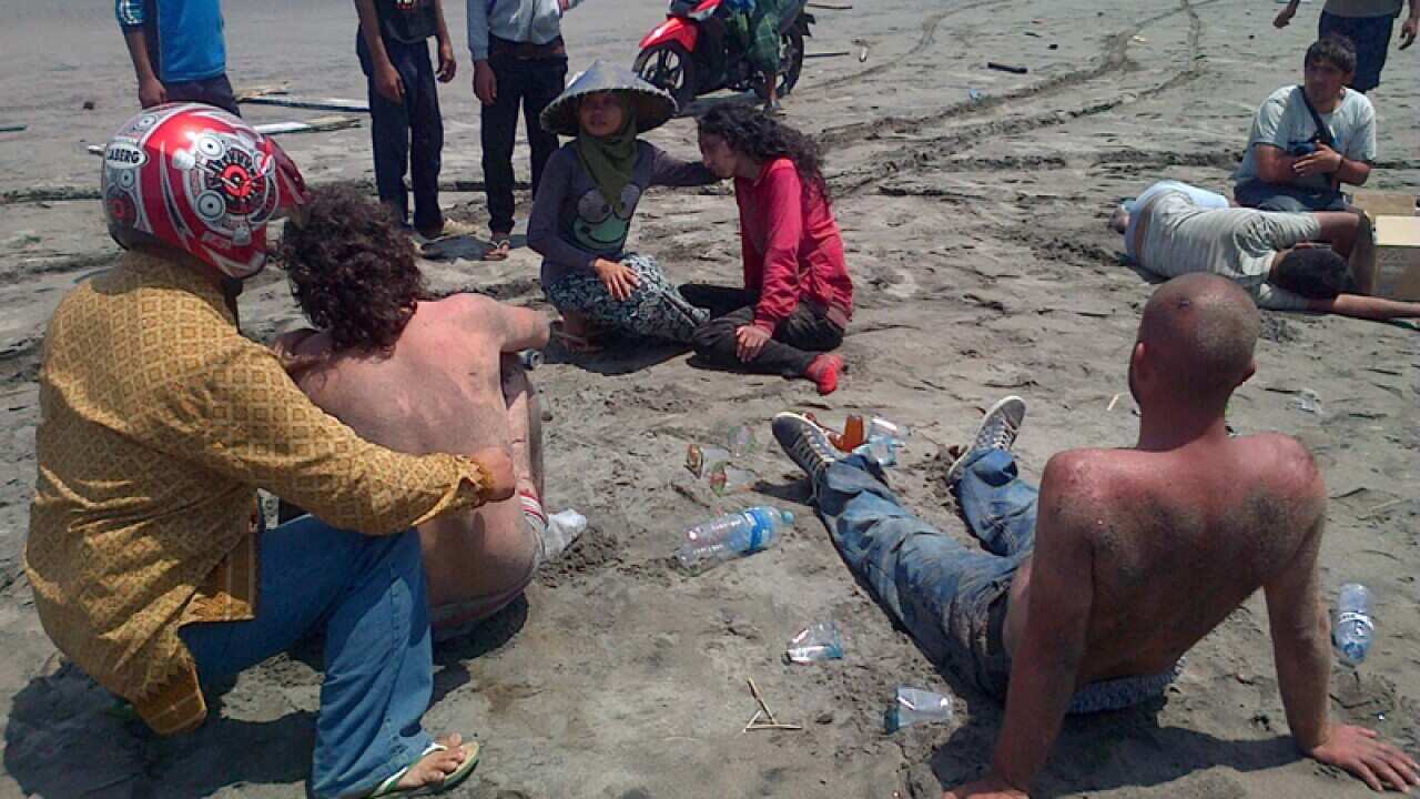 Locals help survivors of from an asylum seeker boat which sank.