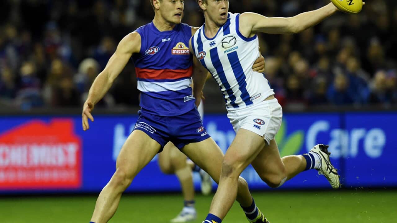 Josh Dunkley of the Western Bulldogs and Trent Dumont of the Kangaroos