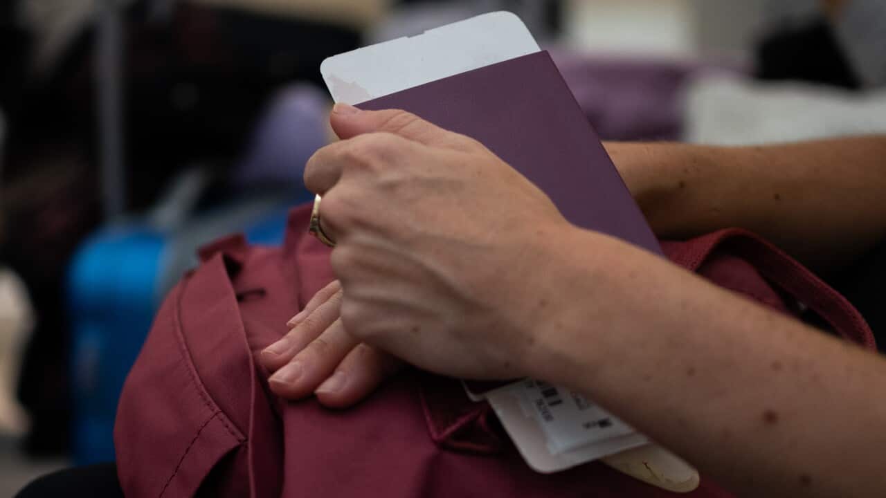 Person waiting, holding passport and boarding pass at the airport terminal