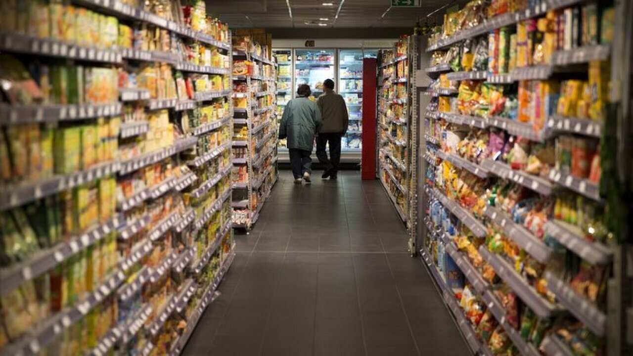 A couple walks in a supermarket food aisle in Paris, France. AFP PHOTO /JOEL SAGET (Photo credit should read JOEL SAGET/AFP/Getty Images)