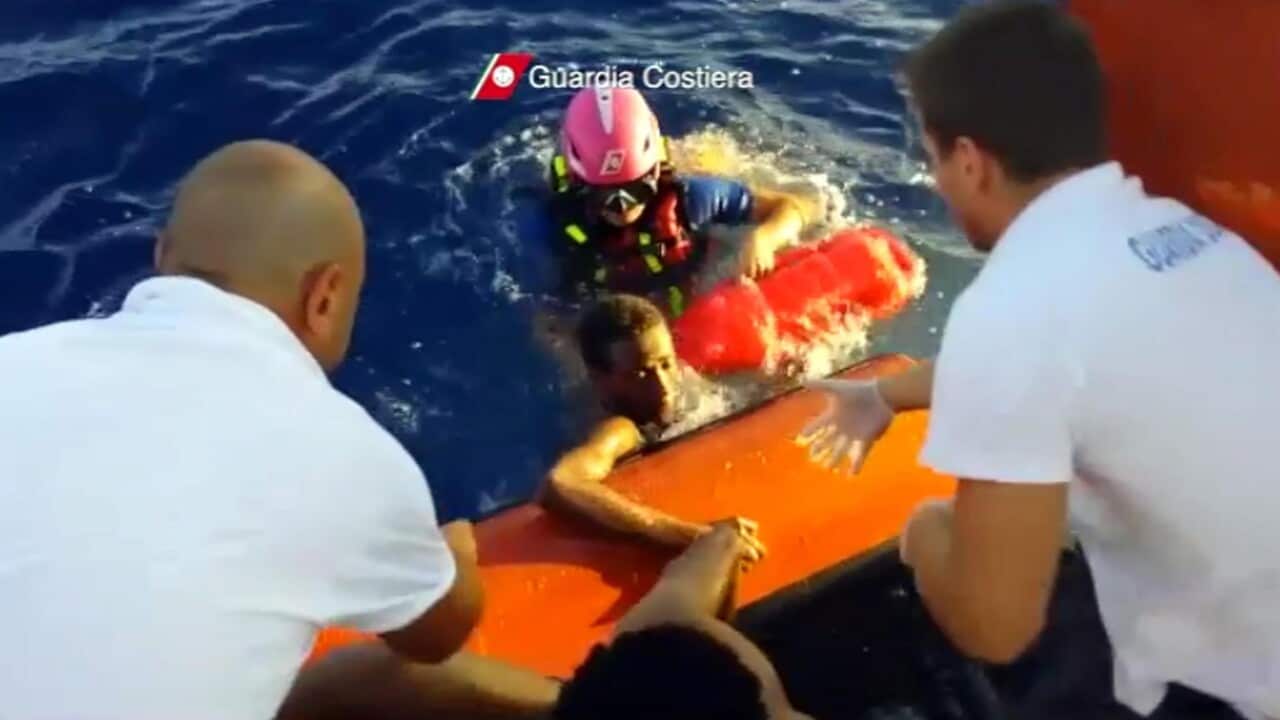 Migrants are pulled onto a rescue boat near Lampedusa on 03 October 2013.  (Supplied) 