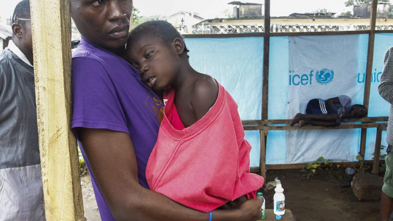 A Liberian man with his daughter at an Ebola clinic