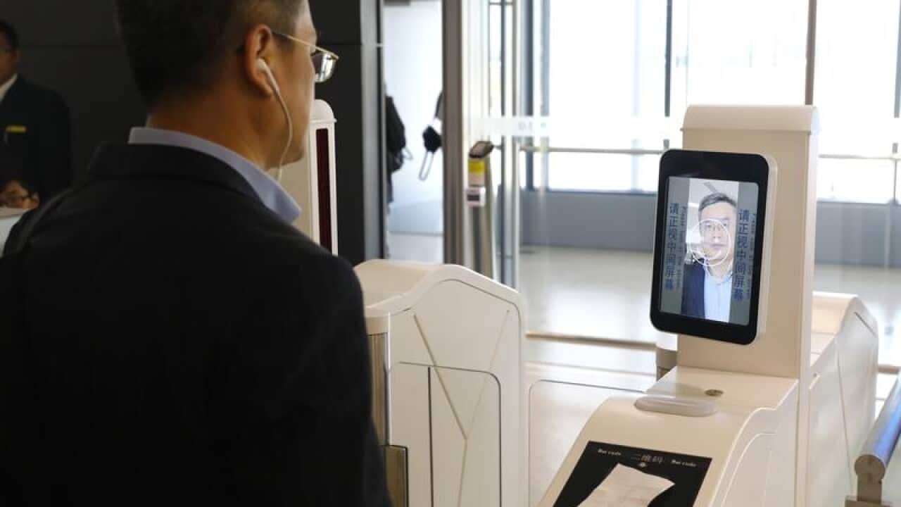 A man at a facial recognition machine at Shanghai airport.